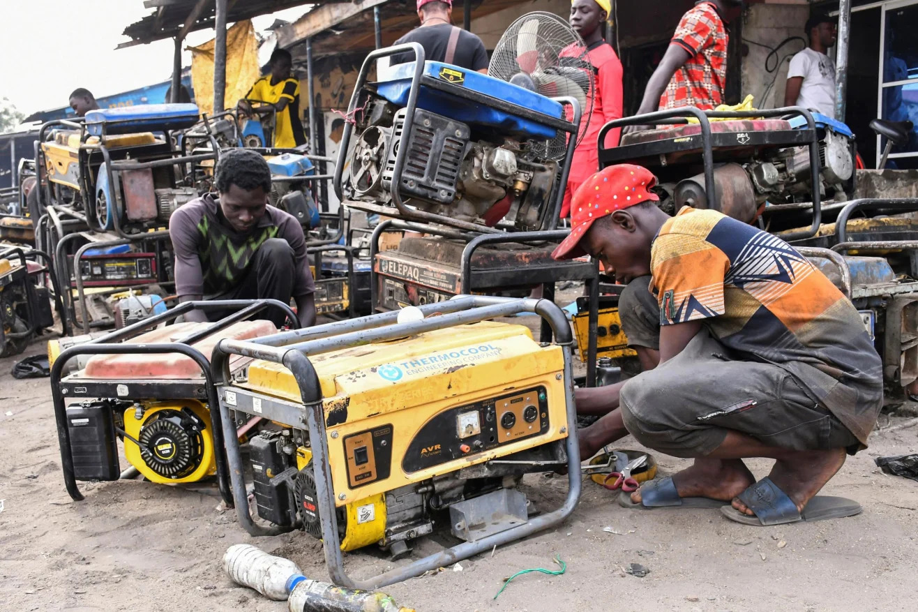 Traders repairing generators at an open-air market